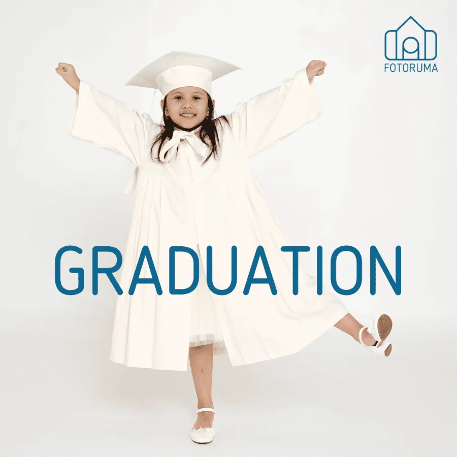 Foto wisuda TK anak dengan toga putih di studio Fotoruma