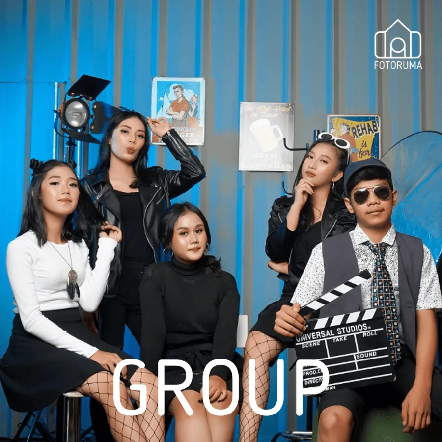 Grup berbusana hitam-putih dengan properti clapperboard di studio Fotoruma